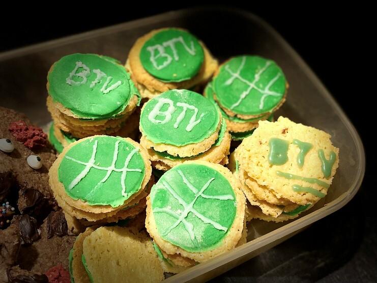 Grüne Kekse mit Basketballmotiv und "BTV"-Aufschrift in einer durchsichtigen Box.