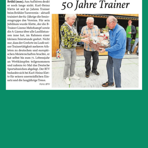 Zwei Männer und eine Frau überreichen einem älteren Mann einen Präsentkorb zur Ehrung seines 50-jährigen Trainerjubiläums.
