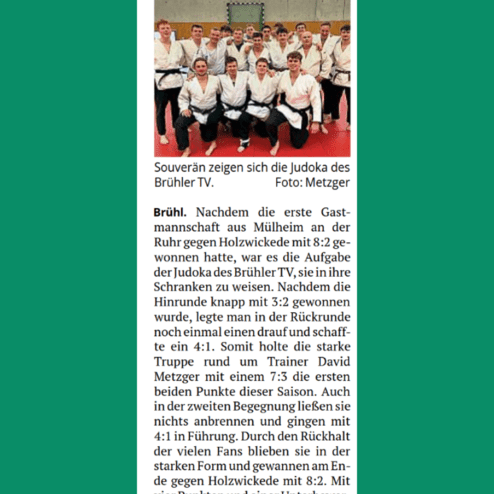 Gruppe von Judoka des Brühler TV posiert auf der Matte in traditioneller Judokleidung.