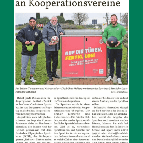 Drei Männer übergeben eine Sportbox mit Sportgeräten. Im Hintergrund sind Bäume und ein Verkehrskreisel sichtbar.