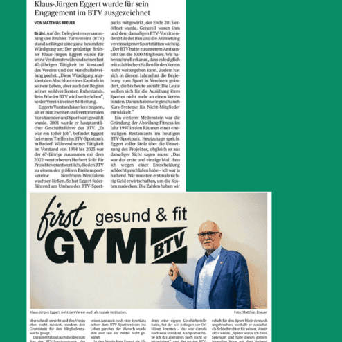 Klaus-Jürgen Eggert steht neben einem Schild mit der Aufschrift „first GYM BTV“ und trägt einen Anstecker des Vereins.