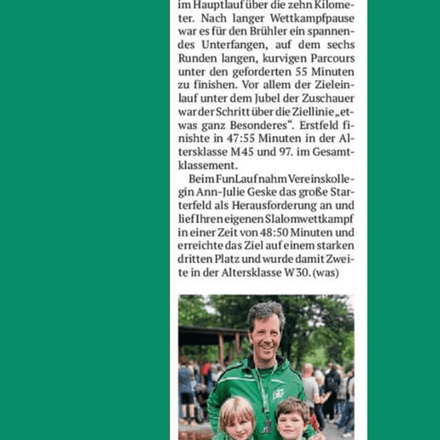 Mann in grüner Sportjacke mit zwei Kindern, die Medaillen halten, vor einer Menschenmenge bei einem Event.