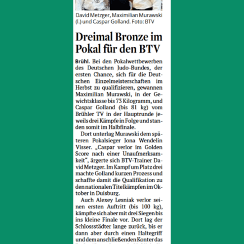 Drei Judoka in Sportkleidung stehen nebeneinander vor einer Tafel mit dem Text über ihre Erfolge im Judo.