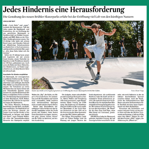 Skater führt einen Trick im neuen Skaterpark in Brühl während der Eröffnung vor einer Gruppe von Zuschauern aus.