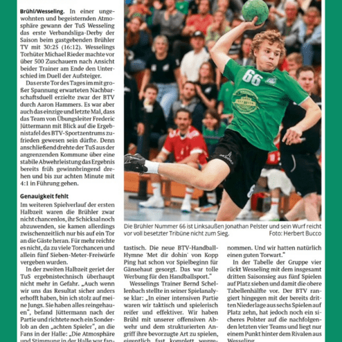 Handballspiel: Spieler mit der Nummer 66 wirft den Ball in einer vollen Halle. Zuschauer verfolgen das Spiel aufmerksam.