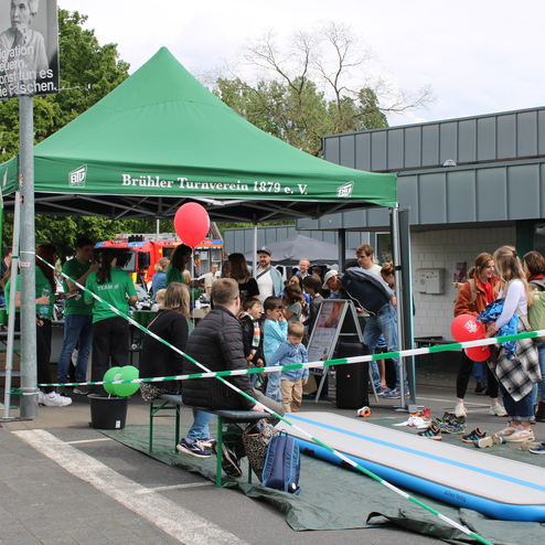 Gr&uuml;ne Zelt des Br&uuml;hler Turnvereins mit zahlreichen Besuchern und Aktivit&auml;ten auf einem Au&szlig;engel&auml;nde.
