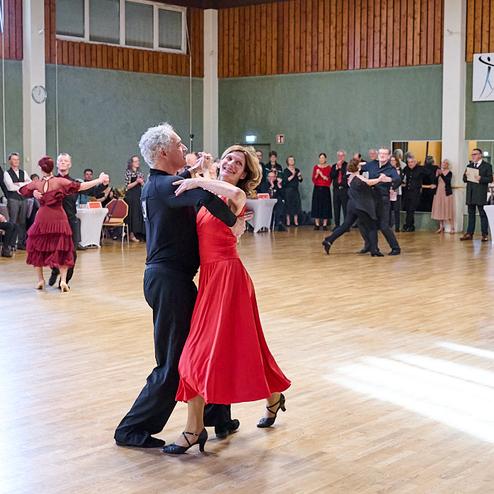 Tanzpaar in eleganter Kleidung tanzt in einem festlichen Saal vor Publikum beim TSC Brühl.