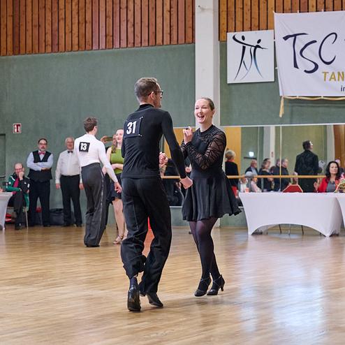 Tanzpaare präsentieren sich auf einer Tanzfläche während einer Wettkampfveranstaltung des TSC Brühl.