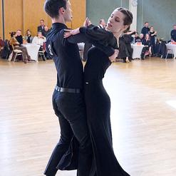 Tanzpaar in eleganter Kleidung f&uuml;hrt einen Walzer auf einer Tanzfl&auml;che in einem festlichen Umfeld aus.