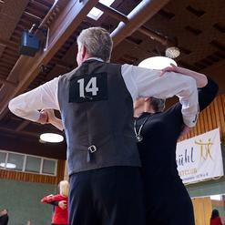 Tanzpaar in eleganter Haltung, der Mann mit Nummer 14 auf dem R&uuml;cken, in einer Turnieratmosph&auml;re.