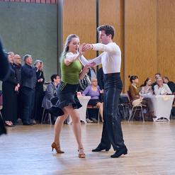 Tanzpaar in eleganter Kleidung f&uuml;hrt einen leidenschaftlichen Tanz auf einer Veranstaltung in einem festlichen Saal aus.