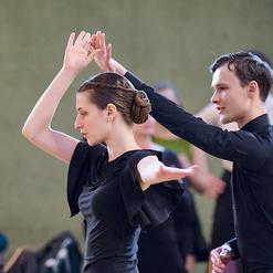 Tanzpaar in eleganter Kleidung w&auml;hrend einer Tanzauff&uuml;hrung, der Mann h&auml;lt die H&auml;nde der Frau.
