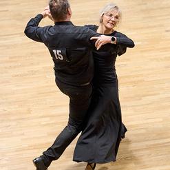 Tanzpaar in eleganter Kleidung f&uuml;hrt einen Tanz auf einem Holzfu&szlig;boden, der M&auml;nner tr&auml;gt eine Nummer 15.