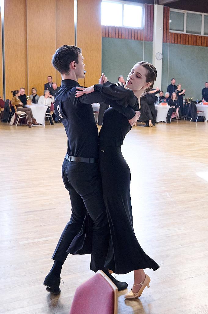 Tanzpaar in eleganter Kleidung f&uuml;hrt einen Walzer auf einer Tanzfl&auml;che in einem festlichen Umfeld aus.