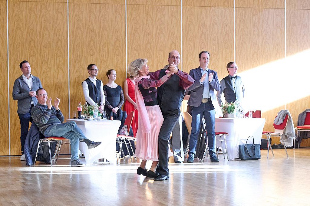 Tanzpaar in festlicher Kleidung f&uuml;hrt einen Tanz auf einer Veranstaltung vor Zuschauern vor.