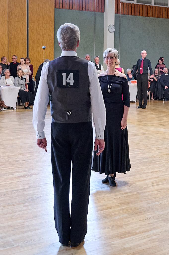 Tanzpaar auf einer Tanzfl&auml;che, Mann mit der Nummer 14 und Frau in schwarzem Kleid stehen sich gegen&uuml;ber.