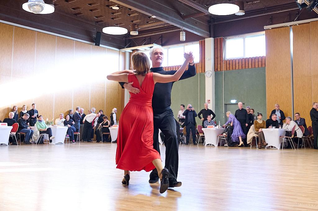 Tanzpaar in eleganter Kleidung f&uuml;hrt einen Paso Doble auf einer Tanzfl&auml;che vor Publikum in festlichem Saal auf.