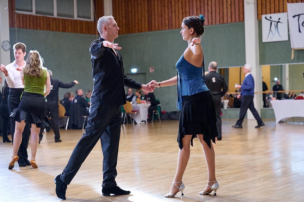 Tanzpaar in eleganter Kleidung vollzieht eine Figurenkombination auf einer Tanzfl&auml;che w&auml;hrend eines Wettbewerbs.