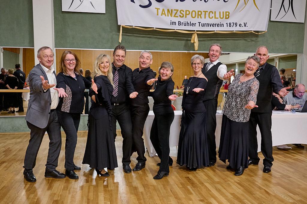 Gruppennahaufnahme von tanzbegeisterten Personen in eleganter Tanzkleidung, die freundlich in die Kamera l&auml;cheln.