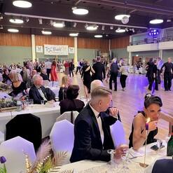 Tanzveranstaltung im TSC Bühl: Paare tanzen auf der Fläche, Gäste sitzen an festlich gedeckten Tischen.