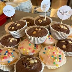 Bunt dekorierte Muffins mit Sahnehaube und bunten Streuseln auf einem Teller, mit Markierungen des TSC B&uuml;hl.