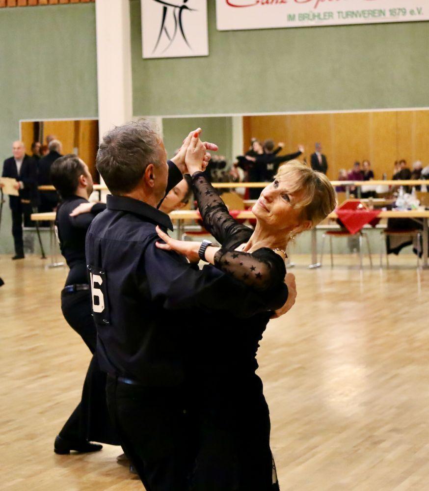 Tanzendes Paar in eleganter Kleidung auf einer Tanzfl&auml;che, im Hintergrund reflektierende Spiegel und Tische.