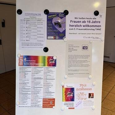 Informationsstand mit Einladungen und Programminformationen für den 5. Frauentagstanz, sowie Kontaktinfos.
