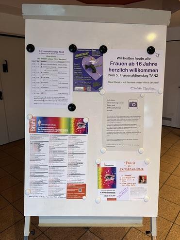 Informationsstand mit Einladungen und Programminformationen für den 5. Frauentagstanz, sowie Kontaktinfos.
