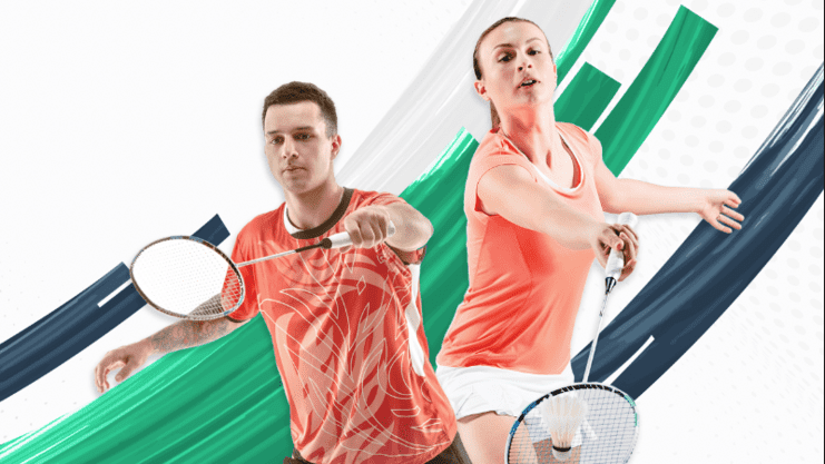 Zwei Badmintonspieler in Aktion, einer mit Schl&auml;ger links, die andere mit Schl&auml;ger rechts, vor dynamischem Hintergrund.