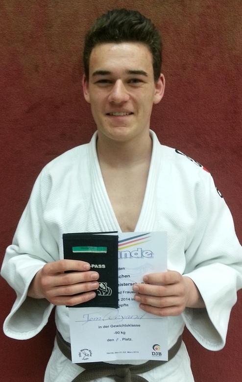 Junger Judoka in weißem Gi hält Urkunde und Wettkampfpass für den 2. Platz in der Gewichtsklasse bis 90 kg.
