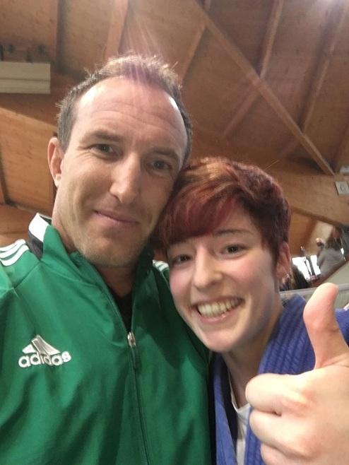 Selbstporträt zweier Personen, ein Mann mit grünem Sportjacke und eine Frau mit kurz geschnittenem Haar, beide lächeln.