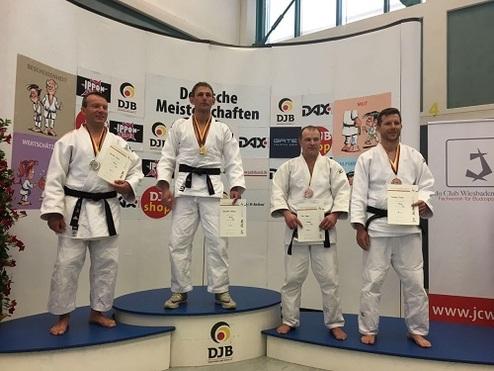 Vier Judokas stehen auf dem Podium der Deutschen Meisterschaften, ein Athlet trägt Goldmedaille, die anderen Silber und Bronze.