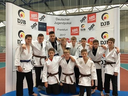 Gruppenfoto von Judokas in weißen und braunen Anzügen vor einem Banner des Deutschen Jugendpokals 2017 in Frankfurt.