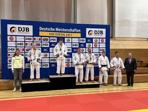 Sieben Jugendliche in Judogis stehen auf dem Siegerpodest bei den U18 Deutschen Meisterschaften in Leipzig 2021.