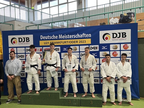 Sechs Judokas stehen auf dem Treppchen bei den Deutschen Meisterschaften U21 2023, umgeben von Sponsorenlogos.
