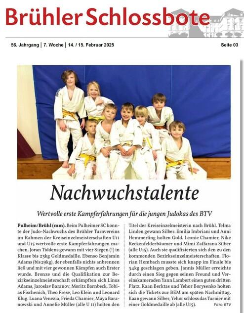 Gruppe von acht jungen Judokas in weißen und gelben Anzügen vor blauer Wand, lächelnd und posierend.