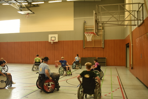 Kinder und Jugendliche die Rollstuhl-Basketball spielen
