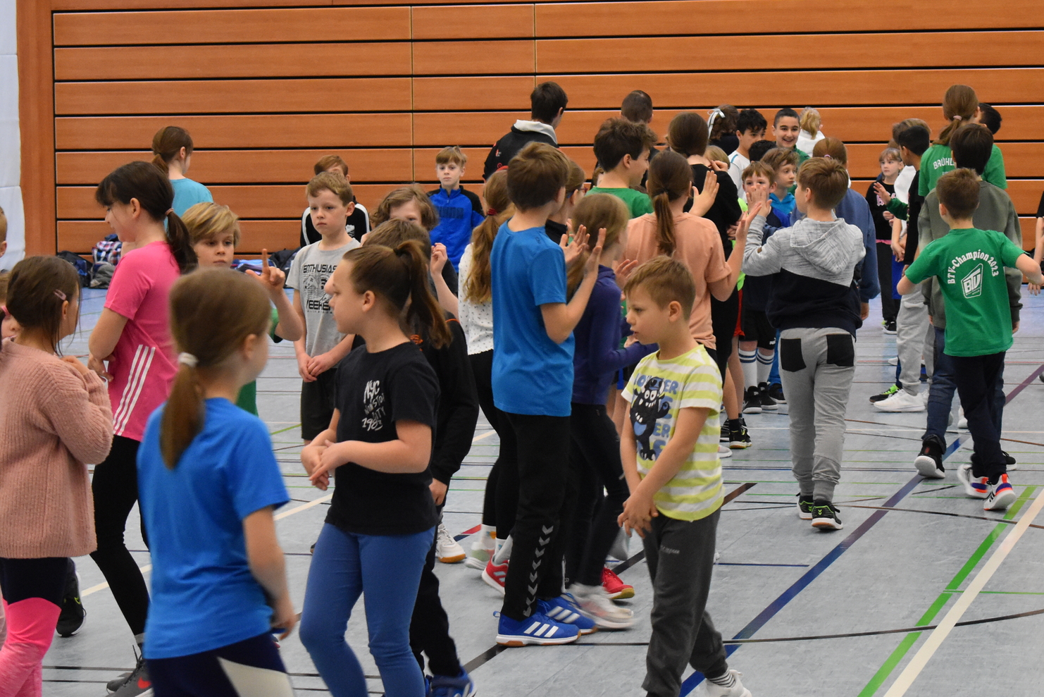 viele Kinder laufen durcheinander in der Sporthalle
