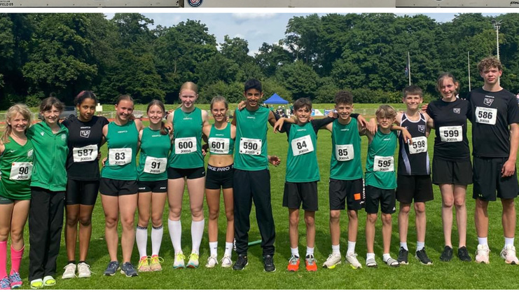 Jugendliche Athleten stehen auf einem Siegertreppchen und posieren in Teameinheit auf einem Sportplatz.