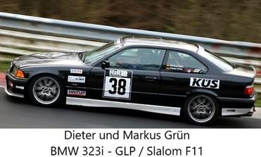 Schwarzer BMW 323i im Rennbetrieb auf einer Strecke mit Nummer 38 und Sponsorenaufklebern an der Karosserie.