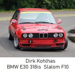 Roter BMW E30 318is fährt auf einer Rennstrecke, mit modernen Reifen und gut sichtbaren Motorsportdetails.