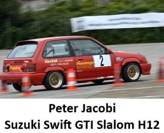 Roter Suzuki Swift GTI fährt durch einen Slalom-Kurs, umgeben von Pylonen.