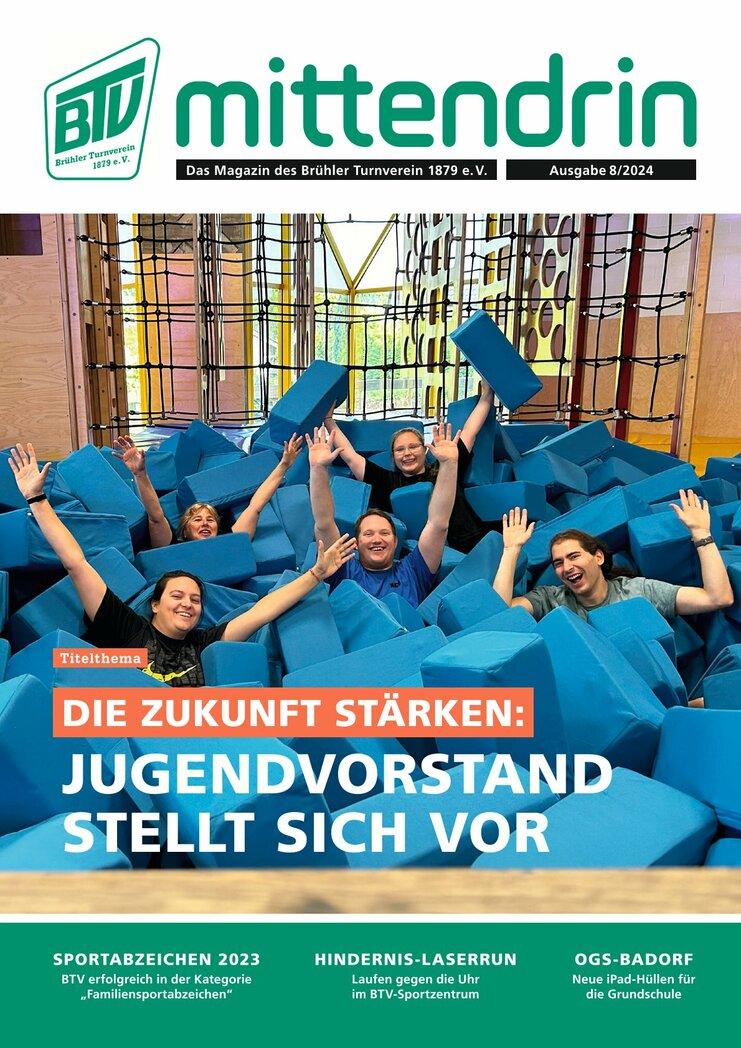 Vierergruppe junger Erwachsener sitzt freudig in einem großen Haufen blauer Schaumstoffblöcke in einer Turnhalle.